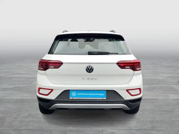 Das Bild zeigt einen VW T-ROC von der Seite, die Farbe des Fahrzeugs ist weiß.