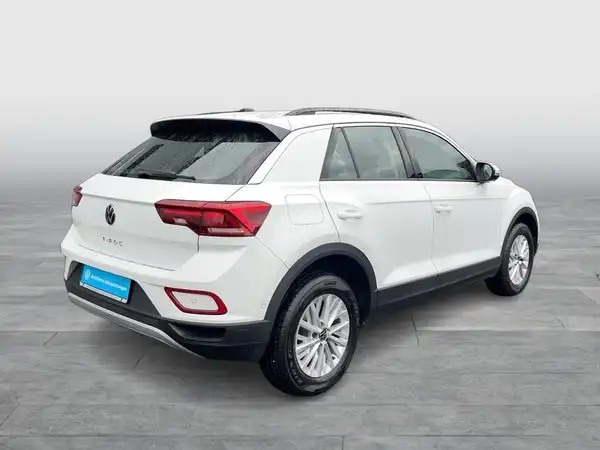 Das Bild zeigt einen weißen VW T-ROC aus der Rückansicht.