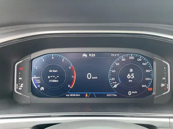 Das Bild zeigt das Armaturenbrett eines VW T-ROC mit einem digitalen Display. Es sind Geschwindigkeits- und Kilometeranzeigen sowie andere Fahrzeugdaten sichtbar. Die Innenfarbe ist schwarz.