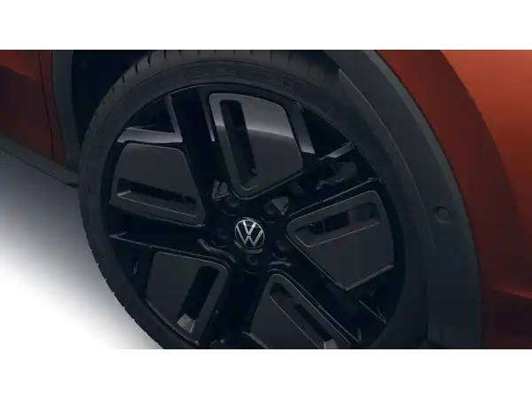 Das Bild zeigt eine Seite eines VW T-Roc mit einem Blick auf das Rad und die Felge. Das Fahrzeug hat die Farbe Orange.
