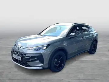 Ein grauer VW T-ROC, von der Seite aufgenommen.