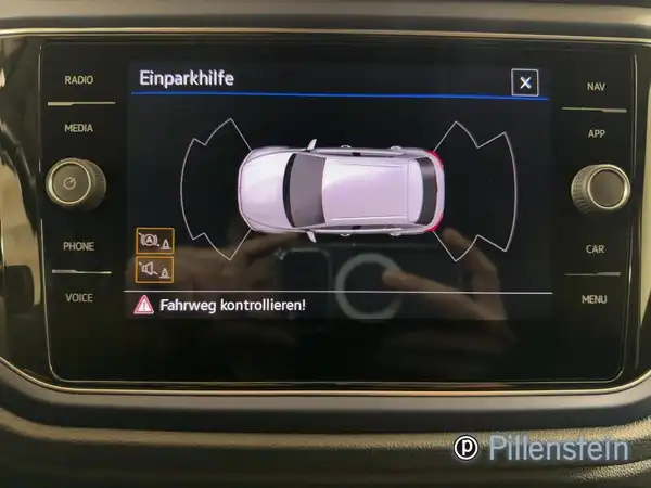 Ein Bild des Innenraums des Fahrzeugs, das die Einparkhilfe auf dem Display zeigt. Die Interieurfarbe ist schwarz und es enthält einen Händlerlogo.