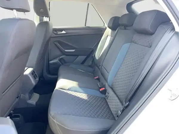 Innenaufnahme des VW T-ROC mit grauem Interieur und blauen Akzenten, die Rückbank ist sichtbar.