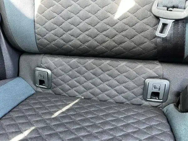 Das Bild zeigt die Rückbank des Fahrzeugs, mit einer gepolsterten Oberfläche in Schwarz und Blau.