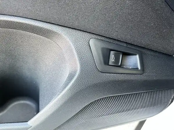 Das Bild zeigt das Innere eines Fahrzeugs, konkret einen Ausschnitt der Türverkleidung auf der Fahrerseite. Die Farbe des Interieurs ist schwarz.
