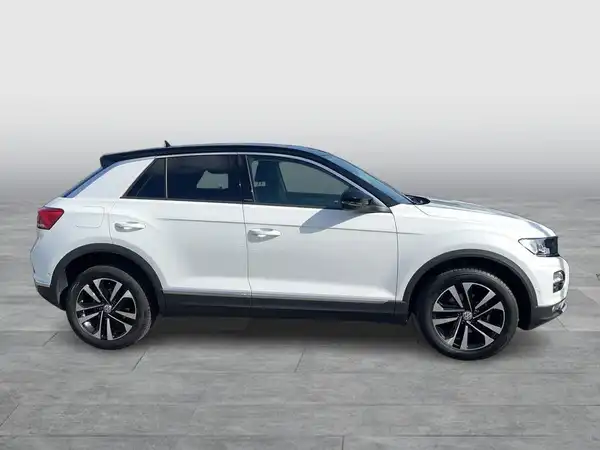 Das Bild zeigt einen weißen VW T-Roc aus seitlicher Perspektive. Es handelt sich um ein Fahrzeugbild ohne Händlerlogo oder markante Texteinblendungen.