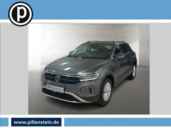 Das Bild zeigt einen grauen Volkswagen T-Roc aus der Frontalansicht. Das Händlerinformationen ist im unteren Bereich des Bildes eingeblendet.