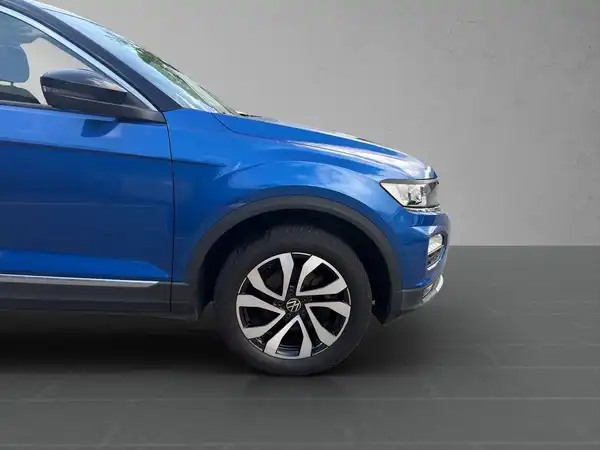 Das Bild zeigt einen blauen VW T-ROC von der Seite.
