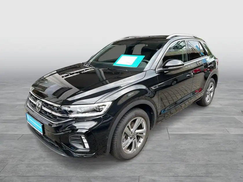 Das Bild zeigt einen schwarzen VW T-ROC aus der Frontansicht mit markanten Texteinblendungen.