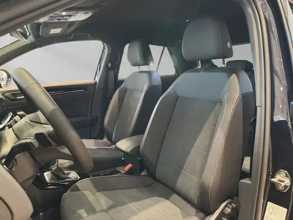 Das Bild zeigt den Innenraum eines VW T-ROC mit schwarzen Stoffbezügen.