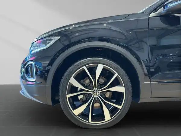 Das Bild zeigt die Seite eines VW T-ROC in schwarzer Farbe.