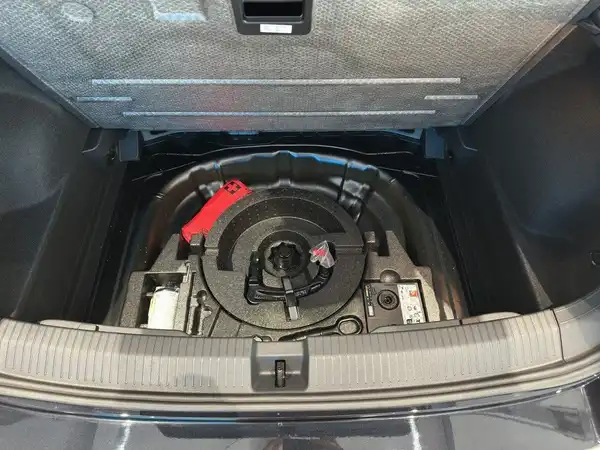 Das Bild zeigt den Kofferraum des Fahrzeugs, mit einem Ersatzrad und Werkzeug.