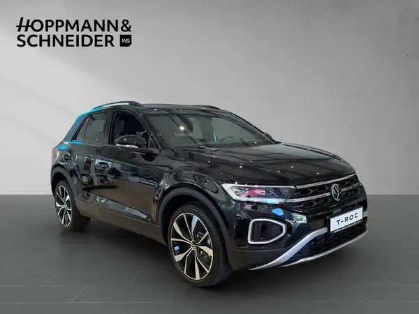 Das Bild zeigt einen schwarzen VW T-ROC aus der Seitenansicht. Das Händlerinlogo "HOPPMANN & SCHNEIDER" ist im oberen Bereich des Bildes eingeblendet.