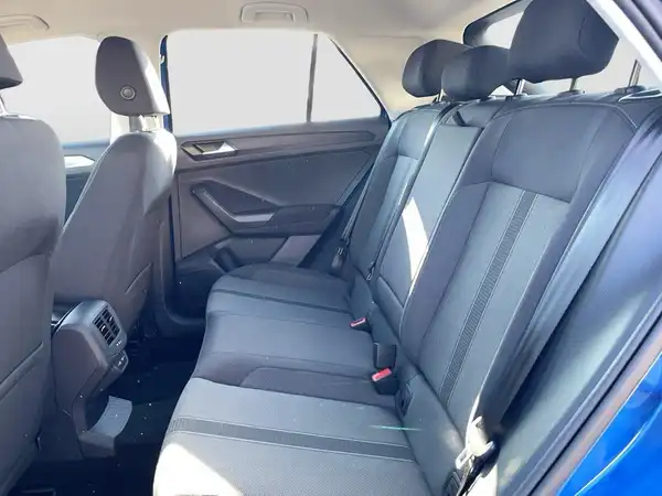 Das Bild zeigt die Rückbank eines blauen VW T-ROC mit schwarzem Interieur. Es handelt sich um eine Innenaufnahme des Fahrzeugs.
