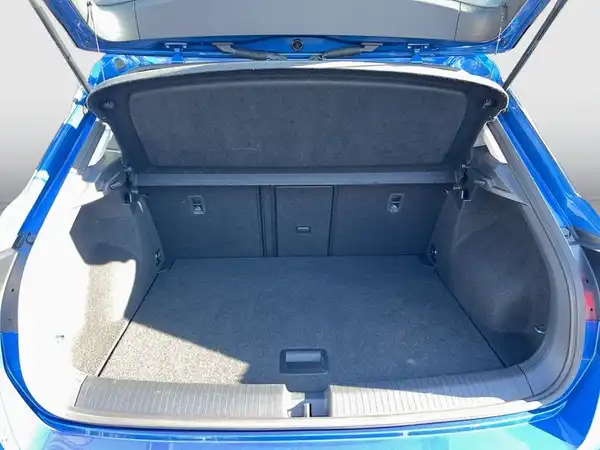 Das Bild zeigt den Kofferraum eines blauen VW T-Roc von hinten.