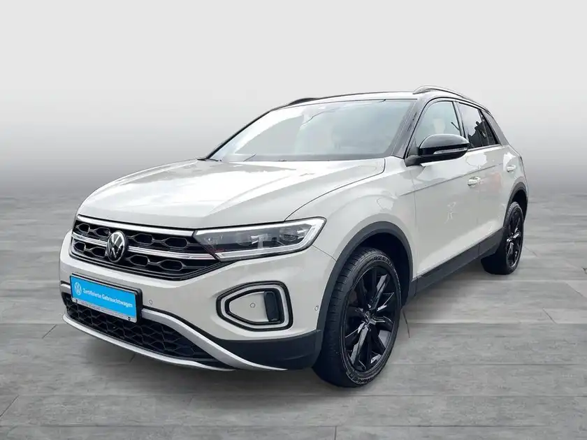 Das Bild zeigt einen weißen VW T-ROC aus der Frontalansicht.