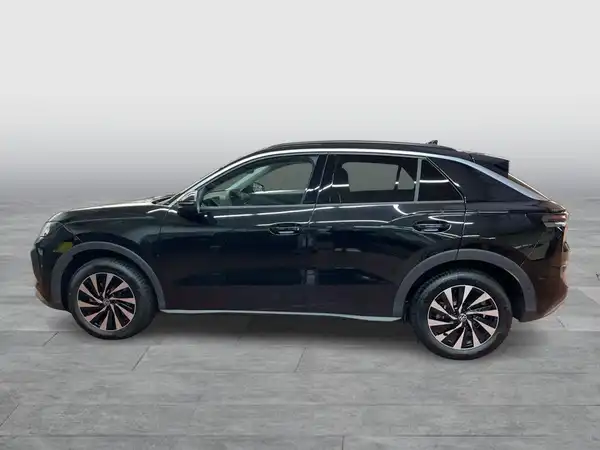 Das Bild zeigt einen schwarzen VW T-ROC aus der Seitenansicht.