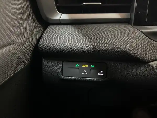 Eine Innenaufnahme des Fahrzeugs, die einen Teil des Armaturenbretts mit einer dunkeltextilen Oberfläche zeigt.