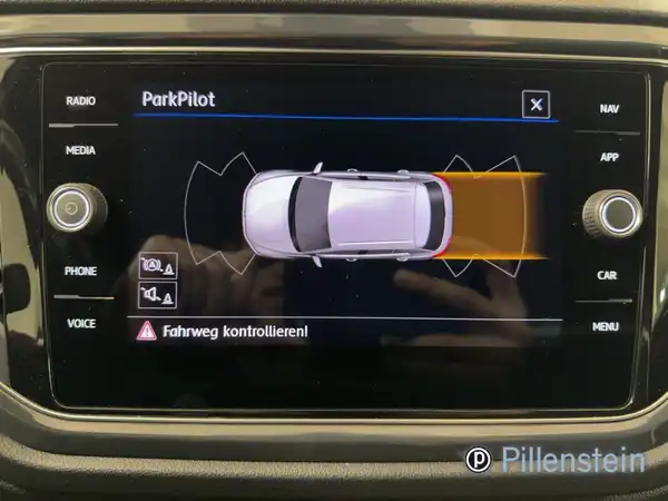 Das Bild zeigt das Innenleben des Fahrzeugs, speziell das Navigationssystem mit Parkpilot-Funktion. Die Anzeige zeigt eine Darstellung des Fahrzeugs und dessen Umgebung. Zusätzlich ist das Händlerlogo "Pillenstein" eingeblendet. Die Interieurfarbe ist schwarz.