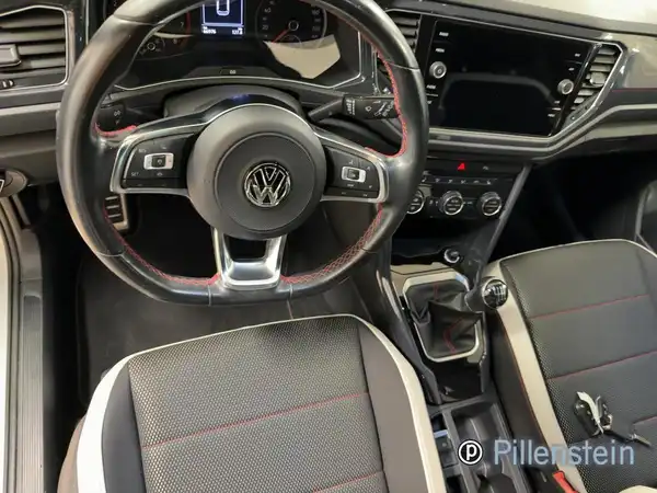 Innenaufnahme eines VW T-ROC mit schwarzem Interieur und roten Akzenten.