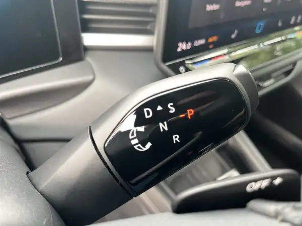 Die Aufnahme zeigt das Innere des Fahrzeugs, insbesondere das Display des Infotainmentsystems, welches Funktionen wie Massage und Klimaanlage anzeigt.