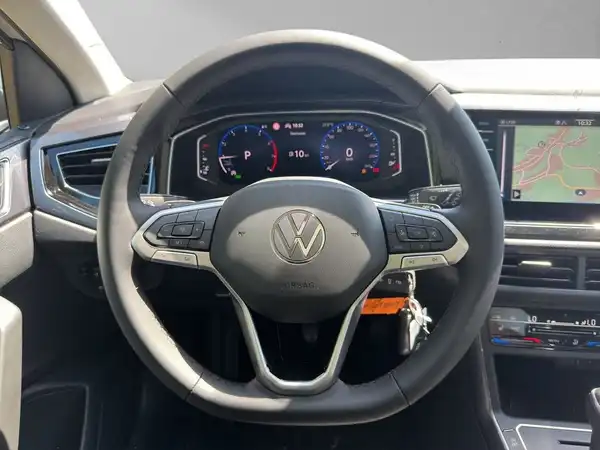 Das Bild zeigt das Innere eines Volkswagen TAIGO, aufgenommen aus der Sicht des Fahrers. Das Lenkrad und das Armaturenbrett sind deutlich zu erkennen. Das Interieur ist schwarz.