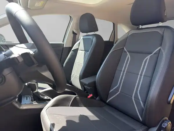 Das Bild zeigt den Innenraum eines Fahrzeugs, mit schwarzen Sitzen und einem Modernen Armaturenbrett.