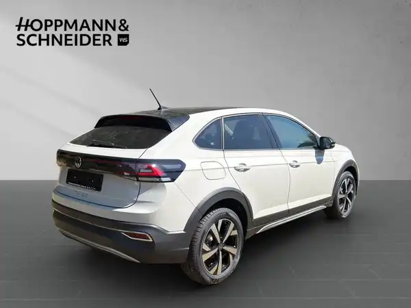 Das Bild zeigt einen weißen VW TAIGO STYLE von der Seite, mit dem Händlerlogo HOPPMANN & SCHNEIDER im oberen Bereich.