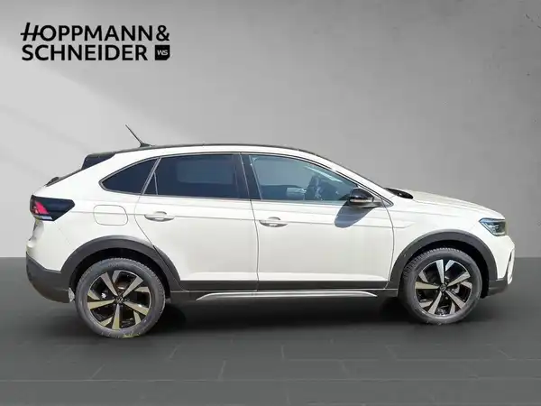 Das Bild zeigt einen weißen VW Taigo im Seitenansicht. Das Händlerlogo 'HOPPMANN & SCHNEIDER' ist eingeblendet.