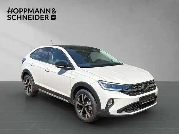 Das Bild zeigt einen VW TAIGO STYLE in weißer Farbe, aus der Seitenansicht. Es ist ein Händlerlogo 'HOPPMANN & SCHNEIDER' im Bild integriert.