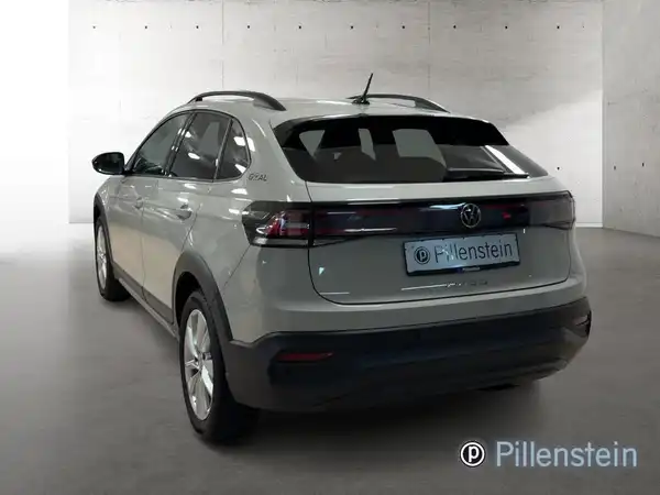 Das Bild zeigt einen VW Taigo von hinten in grauer Farbe. Es enthält das Händlerlogo.