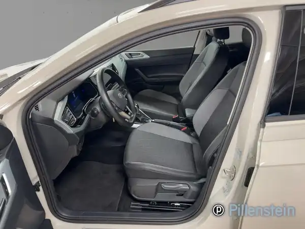 Das Bild zeigt das Innere eines VW Taigo. Die Sitze sind dunkelgrau mit Stoffbezug und es handelt sich um eine Innenaufnahme.