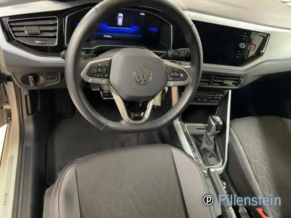 Das Bild zeigt den Innenraum eines VW Taigo aus der Fahrersicht mit einem schwarzen Interieur.