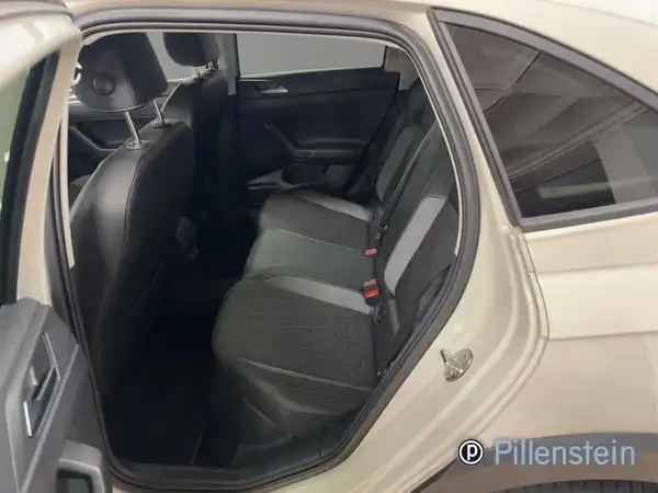 Das Bild zeigt den Innenraum eines VW Taigo, aufgenommen von der Rückbank. Der Innenraum ist schwarz und es sind drei Rücksitzplätze zu sehen.