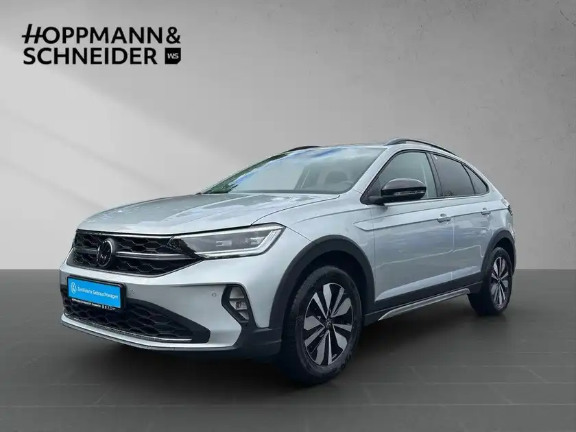 Das Bild zeigt einen silbernen VW Taigo aus der Seitenansicht mit dem Händlerlogo HOPPMANN & SCHNEIDER.