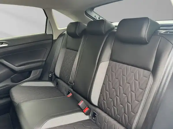 Das Bild zeigt die Rücksitze eines Fahrzeugs mit schwarzem Interieur und quilted Muster.