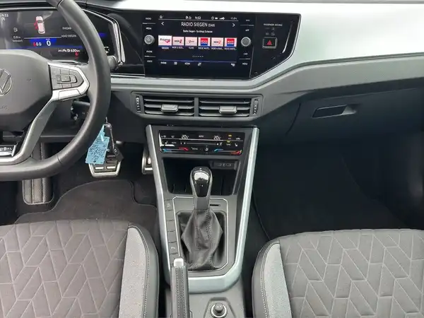 Das Bild zeigt das Innere eines VW Taigo mit einem schwarzen Interieur.