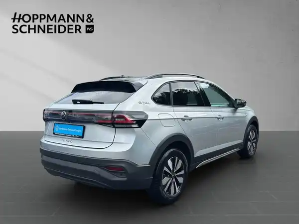 Das Bild zeigt einen silbernen VW Taigo aus der hinteren Perspektive, mit Hoppmann & Schneider als Händlerlogo und markanten Texteinblendungen.