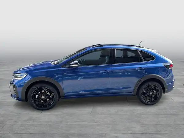 Das Bild zeigt einen VW TAIGO R-Line von der Seite in blauer Farbe.