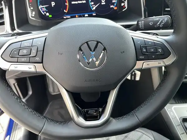 Das Bild zeigt das Lenkrad und das Armaturenbrett eines VW TAIGO R-Line mit einem schwarzen Interieur.