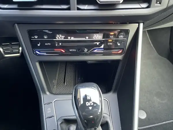 Das Bild zeigt das Innere eines VW TAIGO R-LINE, speziell die Mittelkonsole mit Klimaanlage und Schaltknüppel in schwarzer Farbgebung.