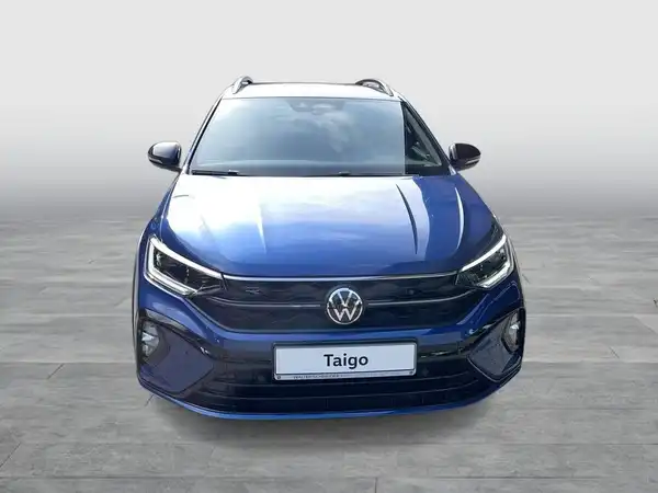 Das Bild zeigt einen blauen VW Taigo aus der Frontalansicht.