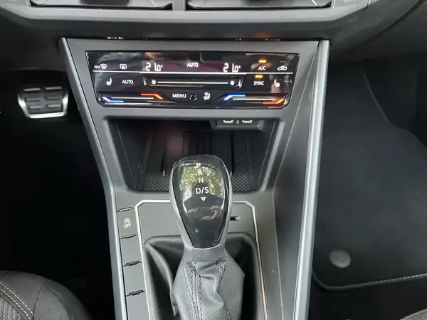 Das Bild zeigt das Innenraum des VW TAIGO R-Line mit einer schwarzen Innenausstattung. Es ist eine Aufnahme von der Mittelkonsole und dem Schaltknauf.