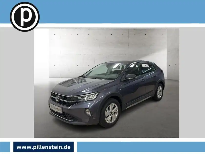 Das Bild zeigt einen grauen VW Taigo von vorne, das Händlerlogo ist eingeblendet und es sind markante Texteinblendungen zu sehen.