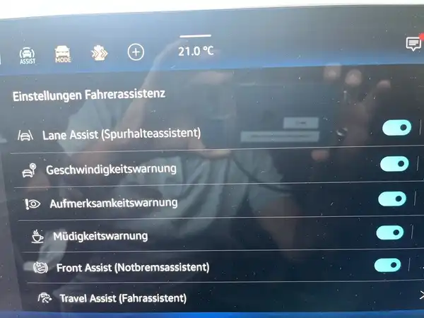 Das Bild zeigt eine Innenaufnahme des Fahrzeugs mit einer Rückfahrkamera-Ansicht. Es sind weitere Fahrzeuge im Hintergrund sichtbar.