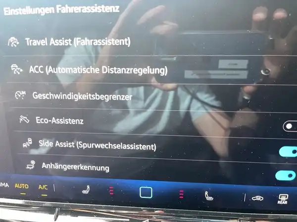 Das Bild zeigt eine Innenansicht des Fahrzeugs, speziell das Bedienfeld mit den Einstellungen für den Fahrerassistenzsystem. Die Innenfarbe ist schwarz.