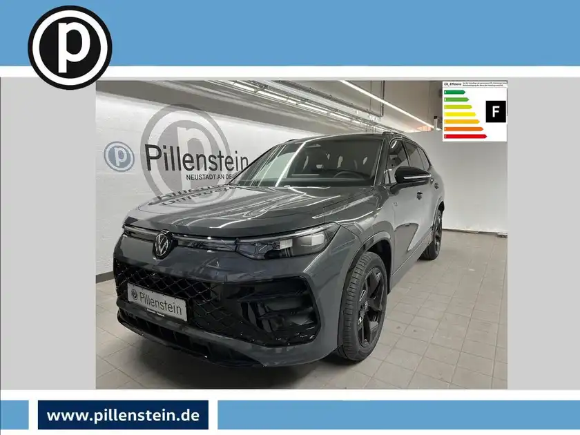 Das Bild zeigt einen schwarzen VW Tayron von der Seite. Im Hintergrund ist das Händlerlogo von Pillenstein sichtbar und es gibt markante Texteinblendungen. Das Fahrzeug ist in einem modernen Ausstellungsraum abgebildet.