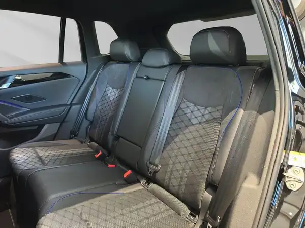 Das Bild zeigt den Rücksitzbereich eines VW Tiguan mit schwarzen Ledersitzen, die eine gesteppte Optik aufweisen.