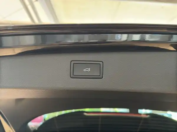 Das Bild zeigt den Innenraum des Fahrzeugs, genauer gesagt einen Knopf im Kofferraumbereich.