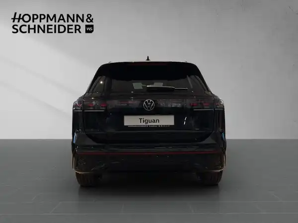 Das Bild zeigt die Rückansicht eines schwarzen VW Tiguan. Es enthält das Händlerdealerlogo "HOPPMANN & SCHNEIDER" und den Schriftzug "Tiguan".